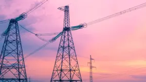 Augstsprieguma elektrotīkla balsti un vadi uz skaidras debess fona Ventspils kontekstā.