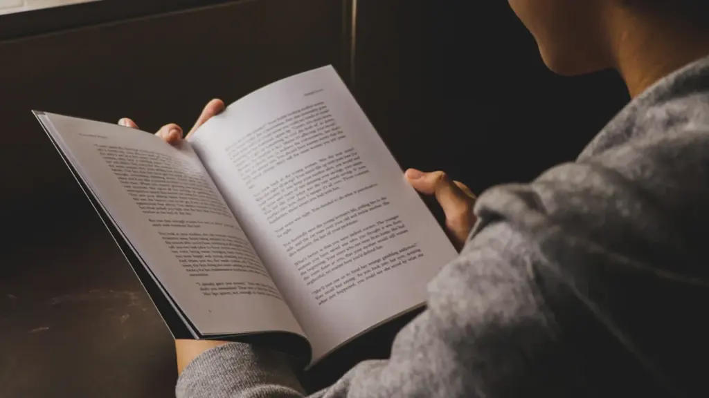 Persona lasa atvērtu grāmatu ar tekstu, gatavojoties gaidāmajiem Dzejas dienu pasākumiem Rēzeknē.