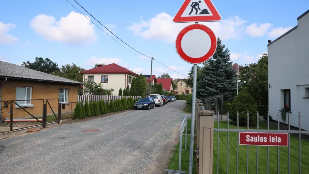 Ceļa zīmes par ceļu remontu un iebraukšanas aizliegumu uz mazas ielas ar privātmājām.